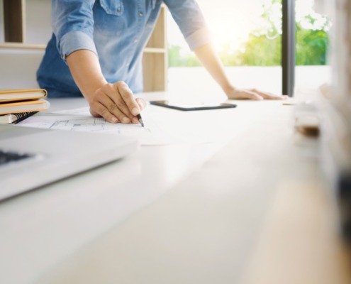 college student standing at table working on homework